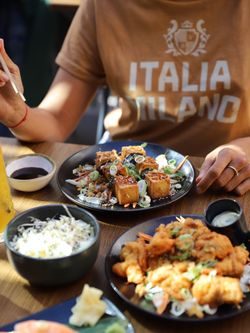 Plat asiatique avec tofu, légumes et riz dans un restaurant japonais avec terrasse ensoleillée.