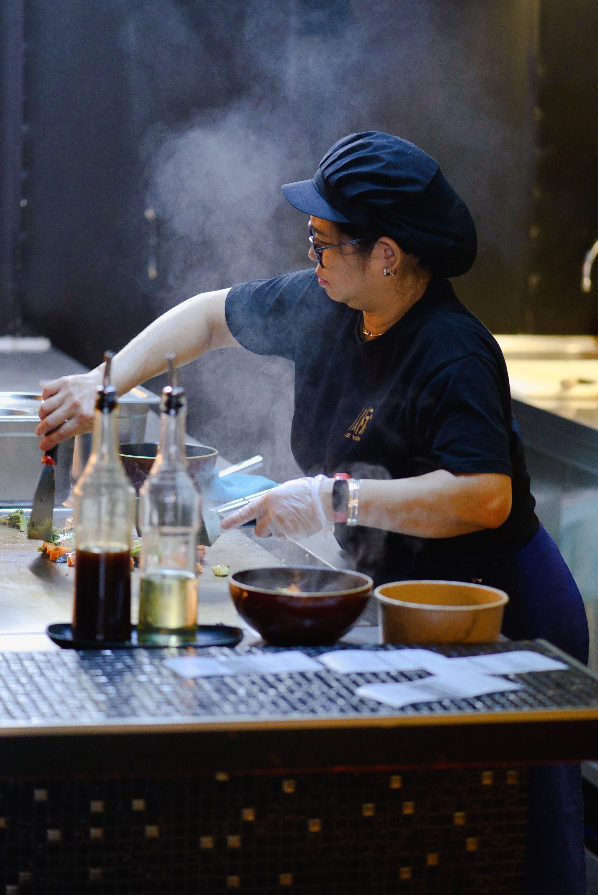 Dans le restaurant Seiiki Le Yen, un chef prépare des plats asiatiques avec soin, mettant en avant des saveurs japonaises.
