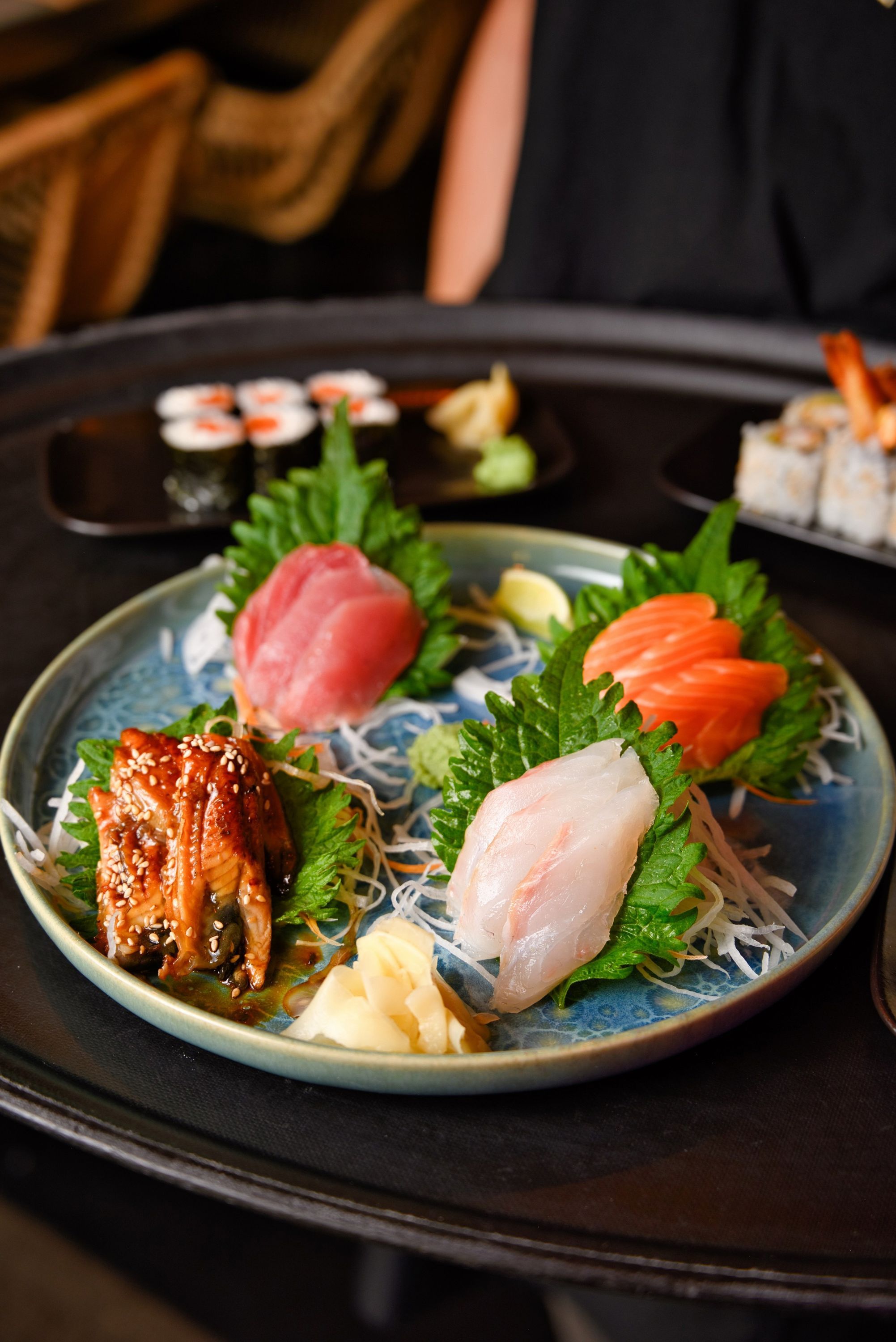 Assiette de sashimis variés accompagnée de garnitures de légumes, servie au restaurant Le Yen Koï.