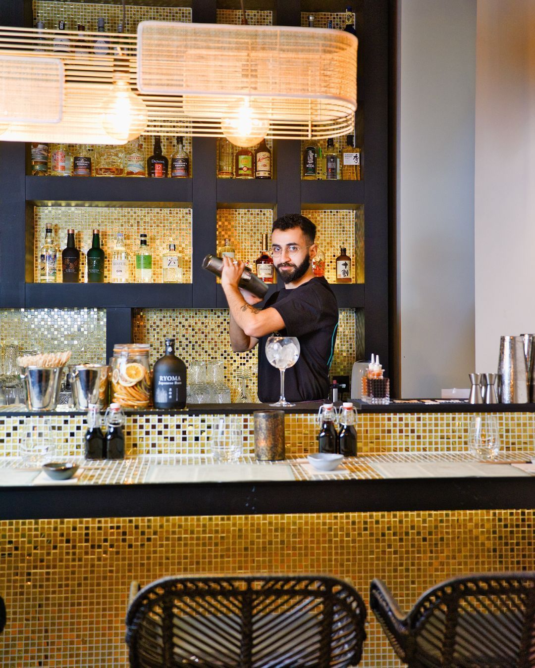 Bar du restaurant Le Yen Koï, avec un barman préparant des cocktails et une décoration moderne en mosaïque.